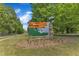 An eye-level sign for J.B. Flaherty Park, set amidst green trees and grass, promotes the outdoor community space at 604 Young Forest Dr, Wake Forest, NC 27587