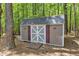 Close-up of backyard storage shed with double doors, ramp and decorative trim at 604 Young Forest Dr, Wake Forest, NC 27587