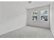 Bright, empty bedroom with gray carpet and white walls, featuring two windows letting in natural light at 6406 Tanner Oak Ln, Raleigh, NC 27613