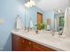 Bathroom with light blue walls, double sinks, and views of the wooded surroundings at 673 Brookview Dr, Chapel Hill, NC 27514