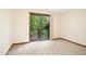 Bright bedroom with gray carpet, sliding glass doors to a deck, and wooded views at 673 Brookview Dr, Chapel Hill, NC 27514