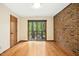 Bedroom with hardwood floors, a brick accent wall, and sliding glass doors to a deck at 673 Brookview Dr, Chapel Hill, NC 27514