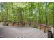 Wood deck with metal railing provides outdoor living space surrounded by many green trees at 673 Brookview Dr, Chapel Hill, NC 27514