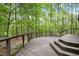 Wood deck with metal railing provides outdoor living space surrounded by many green trees at 673 Brookview Dr, Chapel Hill, NC 27514