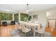 Sunlit dining room with modern light fixture, seating for six and hardwood floors and serene backyard views at 673 Brookview Dr, Chapel Hill, NC 27514