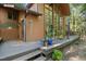 The side of a brown house showcasing a deck adorned with potted plants and a wall of beautiful windows at 673 Brookview Dr, Chapel Hill, NC 27514