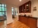 Hallway with wood floors and custom cabinets leading to living room with high ceilings and wooded view at 673 Brookview Dr, Chapel Hill, NC 27514