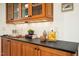 Kitchen counter with glass cabinets, wooden accents, black countertops and stylish décor at 673 Brookview Dr, Chapel Hill, NC 27514