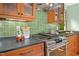 Updated kitchen with stainless steel stove and black countertops complemented by warm wood cabinetry at 673 Brookview Dr, Chapel Hill, NC 27514