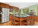 Gourmet kitchen with stainless appliances, center island, green backsplash, and wood cabinetry at 673 Brookview Dr, Chapel Hill, NC 27514