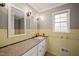 A charming bathroom featuring dual mirrors, a window and tiled walls creating a vintage feel at 6804 Justice Dr, Raleigh, NC 27615