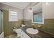 Bathroom featuring green tile, a window, a granite-look countertop, and a framed mirror above the sink at 6804 Justice Dr, Raleigh, NC 27615