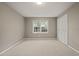 A calm bedroom with neutral tones, plush carpet, and a scenic window view ensuring a peaceful retreat at 6804 Justice Dr, Raleigh, NC 27615