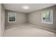 Neutral bedroom featuring carpeted floors, fresh paint, and two windows providing natural light at 6804 Justice Dr, Raleigh, NC 27615