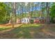 Back exterior view of home through a beautiful wooded property at 6804 Justice Dr, Raleigh, NC 27615