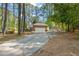 Exterior view of home with a long driveway and mature trees at 6804 Justice Dr, Raleigh, NC 27615