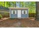 Exterior view of backyard shed with white door and window frames, next to fenced-in lawn at 6804 Justice Dr, Raleigh, NC 27615