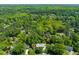 Community aerial view with houses nestled among dense greenery and a small pond at 7 Dubarry Ct, Durham, NC 27705