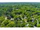 Lush green neighborhood aerial view features tree-lined streets and homes nestled in a verdant setting at 7 Dubarry Ct, Durham, NC 27705