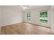Bright bedroom with wood flooring, closet and two windows providing plenty of natural light at 7 Dubarry Ct, Durham, NC 27705