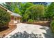 Long driveway with lush trees and landscaping in front of the beautiful brick house at 7 Dubarry Ct, Durham, NC 27705