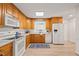 Updated kitchen featuring wooden cabinets, white appliances, and tile backsplash, blending style and functionality at 7 Dubarry Ct, Durham, NC 27705