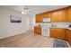 Efficient kitchen featuring ample wooden cabinets, updated white appliances, and a cozy dining area at 7 Dubarry Ct, Durham, NC 27705