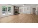 Large living room with wood flooring, brick fireplace, white built-ins, and exterior door to back deck at 7 Dubarry Ct, Durham, NC 27705