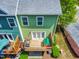 Aerial view of a backyard with a wooden deck, playhouse, and lush greenery at 705 Samuel Cary Dr, Cary, NC 27511