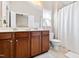 Spacious bathroom with dual sink vanity, a large mirror, and a shower-tub with curtain at 705 Samuel Cary Dr, Cary, NC 27511
