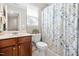 Cozy bathroom with vanity, neutral tile flooring, and a shower-tub with floral curtain at 705 Samuel Cary Dr, Cary, NC 27511