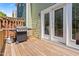 Cozy outdoor deck featuring a grill and access to the home's interior through white-framed glass doors at 705 Samuel Cary Dr, Cary, NC 27511