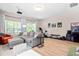 Comfortable and well-lit living room with a gray sofa, exercise equipment, and large windows at 705 Samuel Cary Dr, Cary, NC 27511