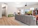 Bright and open living room featuring a comfortable gray sofa, light wood floors, and a large TV with beach view at 705 Samuel Cary Dr, Cary, NC 27511