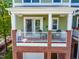 Second story porch with seating on a green home with brick facade at 705 Samuel Cary Dr, Cary, NC 27511