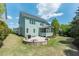 Expansive backyard with a stone patio, a built-in fire pit, and lush green grass at 7101 Gibson Creek Pl, Cary, NC 27519