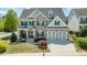 Beautiful two-story home with a stone facade, manicured lawn, and a two-car garage at 7101 Gibson Creek Pl, Cary, NC 27519