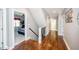 Hallway with hardwood flooring, access to multiple rooms, and staircase at 7101 Gibson Creek Pl, Cary, NC 27519