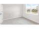 Bright bedroom featuring plush gray carpeting and a sunlit window with neutral walls at 764 Dorset Stream Dr, Fuquay Varina, NC 27526