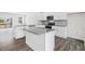 Open-concept kitchen with stainless appliances, gray counter tops, and wood-look floors at 764 Dorset Stream Dr, Fuquay Varina, NC 27526