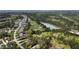Aerial view of the community showcasing homes bordering a golf course, scenic pond, and lush wooded area at 8208 Bella Oak Ct, Wake Forest, NC 27587