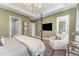 Another angle of this Cozy bedroom with elegant furniture, large windows, and a tray ceiling at 8208 Bella Oak Ct, Wake Forest, NC 27587