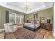 Cozy bedroom with elegant furniture, large windows, and a tray ceiling with chandelier at 8208 Bella Oak Ct, Wake Forest, NC 27587