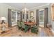Elegant dining room featuring a chandelier, hardwood floors, and green upholstered chairs at 8208 Bella Oak Ct, Wake Forest, NC 27587