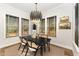 Formal dining room features a modern light fixture, dark table, and lots of natural light at 8208 Bella Oak Ct, Wake Forest, NC 27587