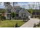 Charming gray two-story home with a lush green lawn and inviting front porch and walkway at 8208 Bella Oak Ct, Wake Forest, NC 27587