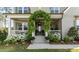 Inviting front porch with a climbing vine archway and lush landscaping around the entrance at 8208 Bella Oak Ct, Wake Forest, NC 27587