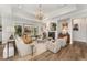 Bright living room with fireplace, elegant chandelier, and large windows overlooking the backyard at 8208 Bella Oak Ct, Wake Forest, NC 27587