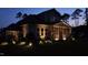 Beautiful home exterior with a screened porch and landscape lighting highlighting the lush lawn at twilight at 8208 Bella Oak Ct, Wake Forest, NC 27587