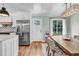 Dining area features a large wooden table, modern light fixture, and stainless steel refrigerator at 905 Tyler Ct, Garner, NC 27529